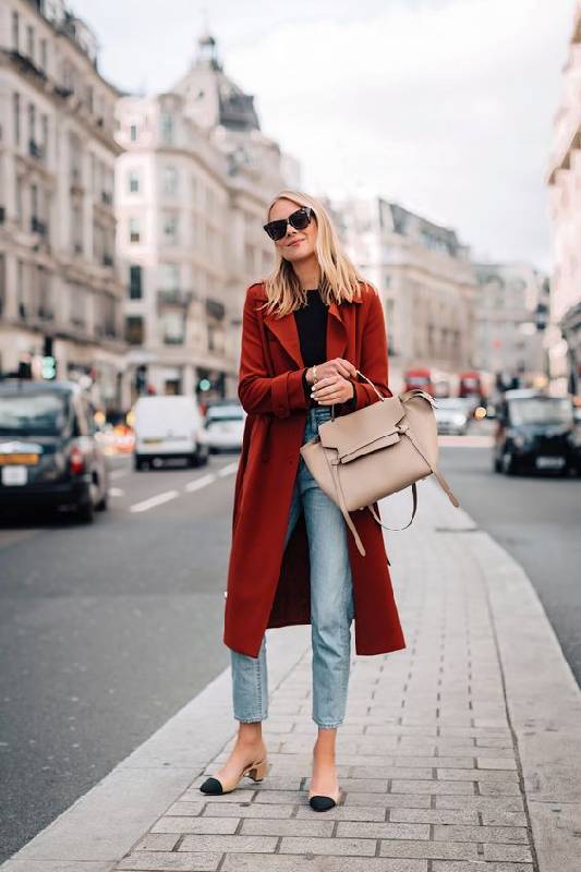 un look audacieux et décontracté avec un tee-shirt noir, un jean bleu clair, un slingbacks bicolore, un fourre-tout beige et un trench bordeaux